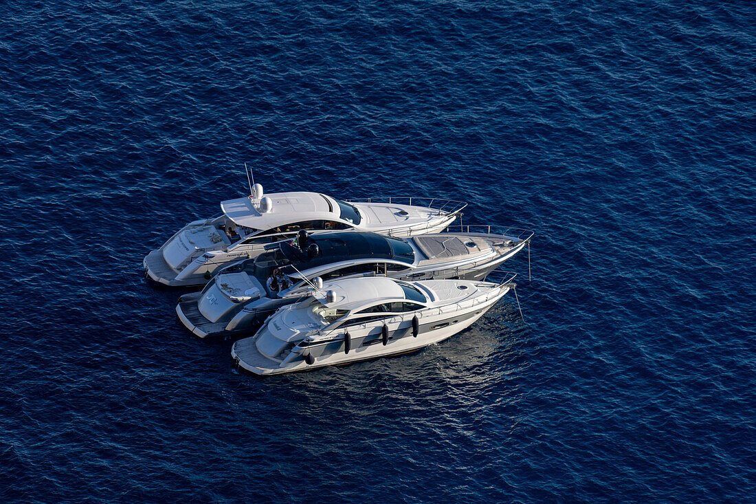 Motor yachts in the waters of the Tyrrhenian Sea off the coast of the island of Capri, Italy.