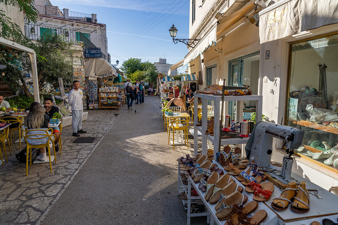 Besucher speisen im Freien in einer Einkaufsstraße in Anacapri auf der Insel Capri, Italien.