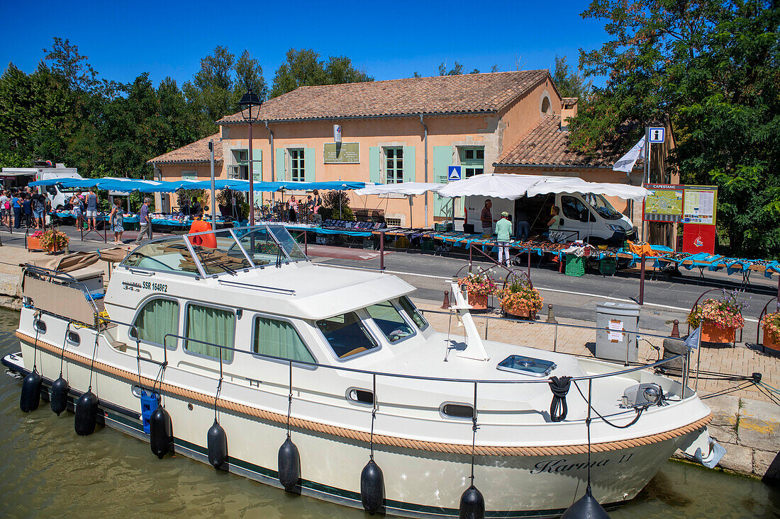 Capestang traditional market Wednesday, Saturday and Sunday. Canal du Midi at Capestang Aude South of France southern waterway waterways holidaymakers queue for a boat trip on the river, France, Europe