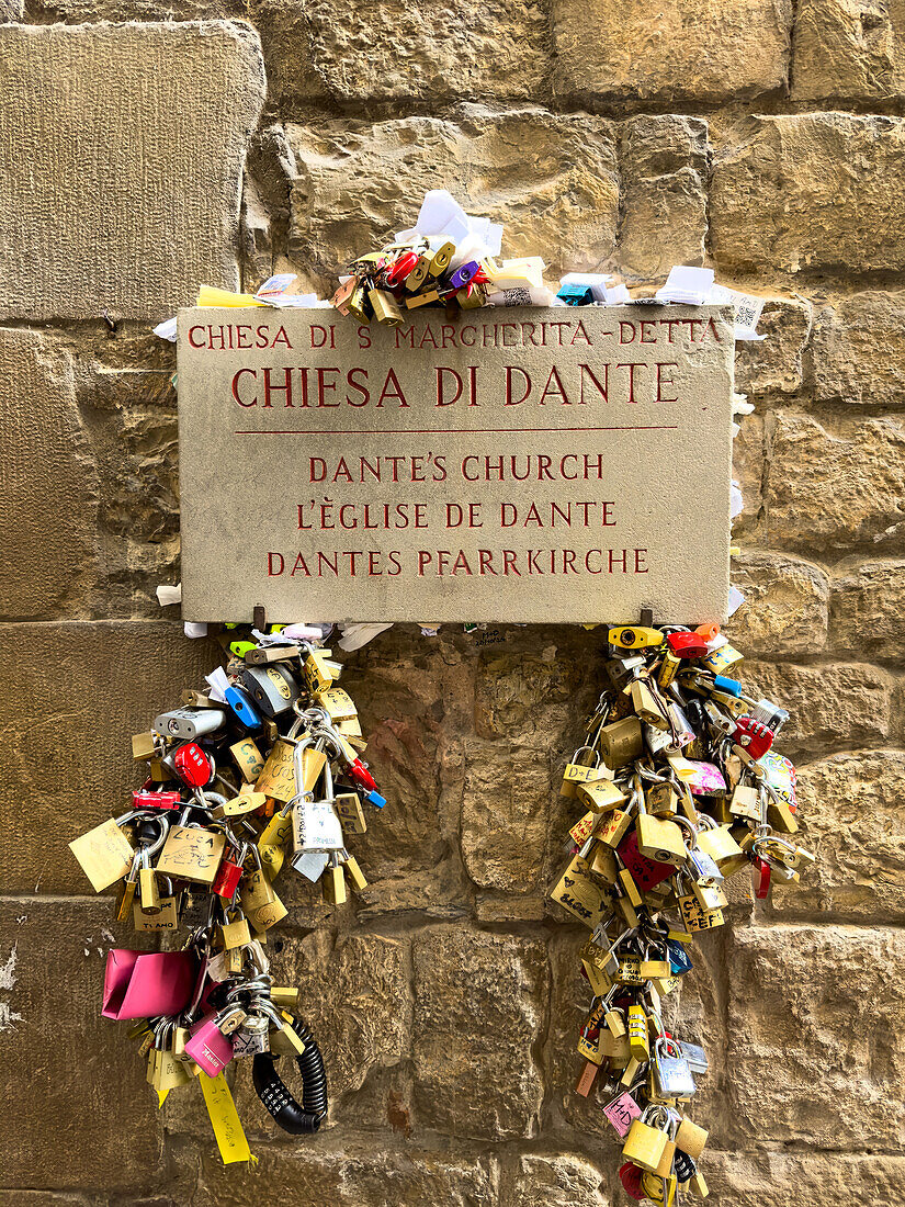 Vorhängeschlösser von Verliebten an der Fassade der Kirche der Heiligen Margarete von Antiochien in Florenz, Italien. Es war die Kirche von Dante Alighieri und der Ort, an dem er Beatrice Portinari zum ersten Mal sah.