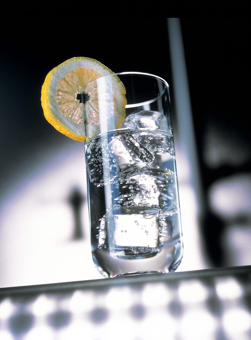 Ein Glas Mineralwasser, garniert mit Zitronenscheibe