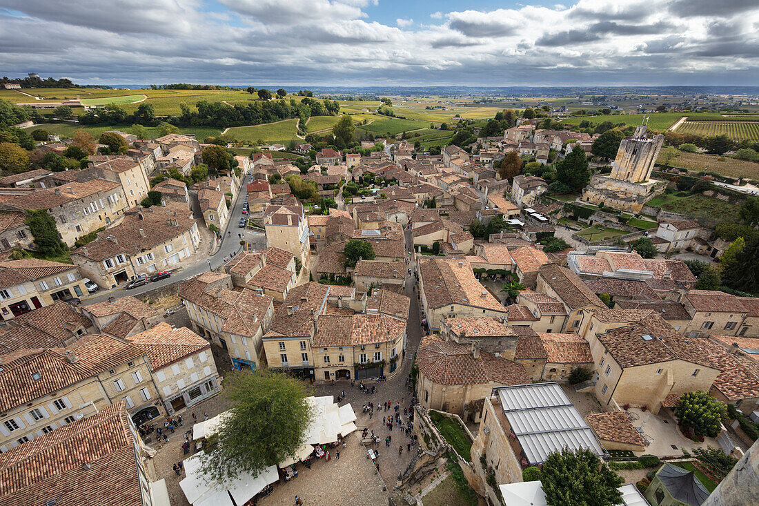 Blick über die mittelalterliche Altstadt mit Weinbergen in der Ferne von der Spitze des Glockenturms der monolithischen Kirche, Saint Emilion, Departement Gironde, Nouvelle Aquitaine, Frankreich, Europa