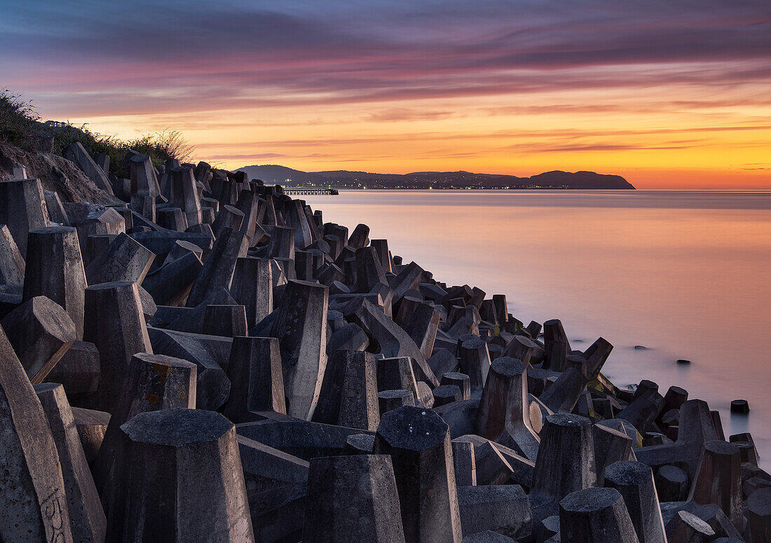 Sea Defences on Llanddulas Beach backed by The Great Orme at sunset, Llanddulas, near Abergele, Conwy County Borough, North Wales, United Kingdom, Europe