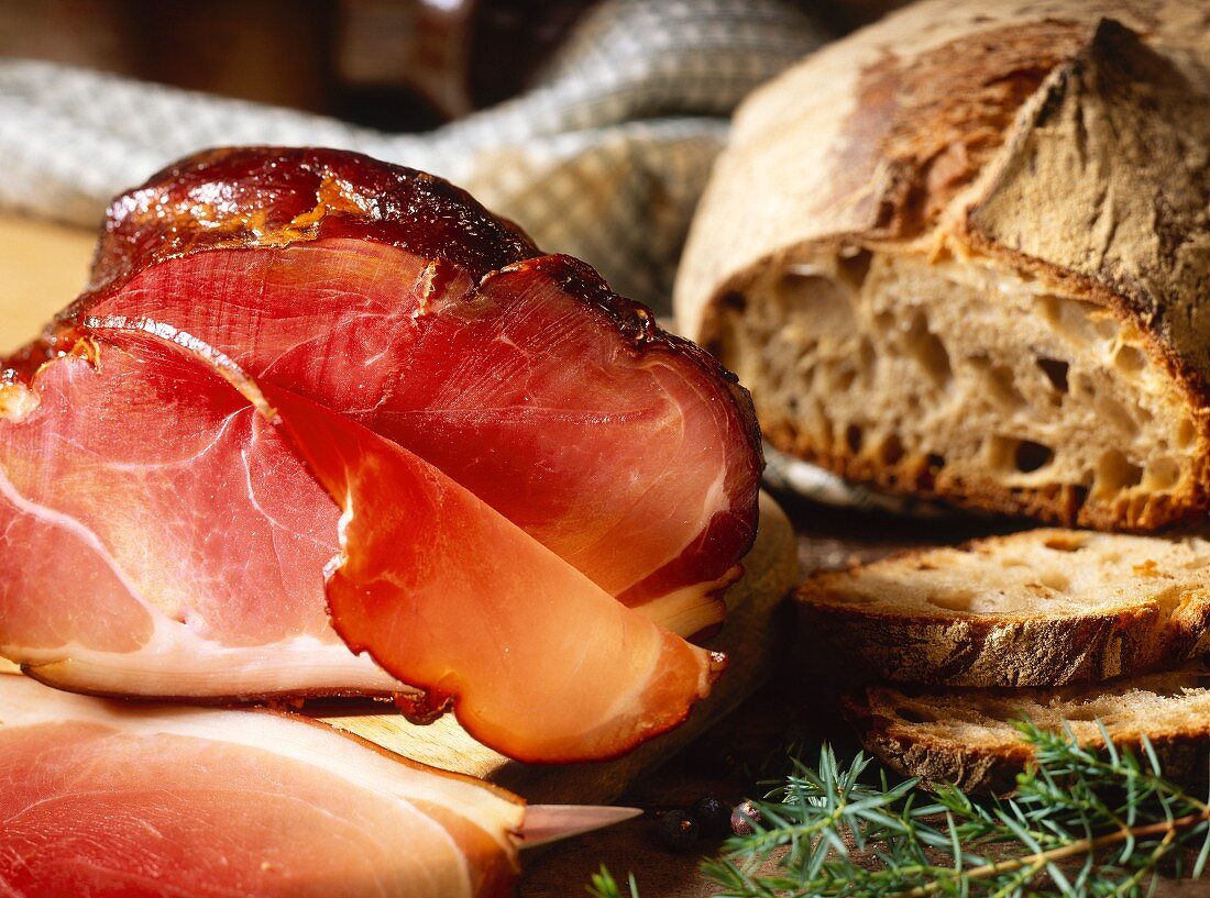 Westphalian ham, cut into and a loaf of rye bread