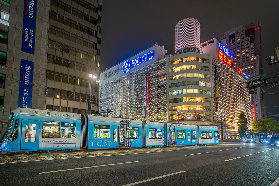 View of street scene, city tram and buildings in Hiroshima at night, Hiroshima, Honshu, Japan