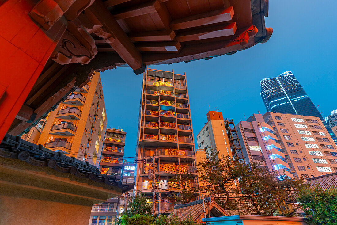 View of Tokyo Tower reflecting in city buildings and Rurikoji Buddhist Temple at night, Minato City, Tokyo, Honshu, Japan