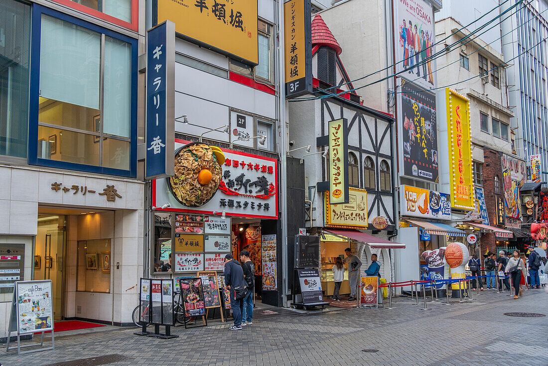 Blick auf Restaurants und Geschäfte in Dotonbori, pulsierendes Vergnügungsviertel in der Nähe des Flusses, Osaka, Honshu, Japan