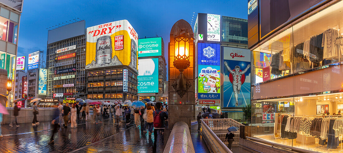 Blick auf das Glico-Schild in Dotonbori, einem pulsierenden Vergnügungsviertel in der Nähe des Flusses, in der Abenddämmerung, Osaka, Honshu, Japan