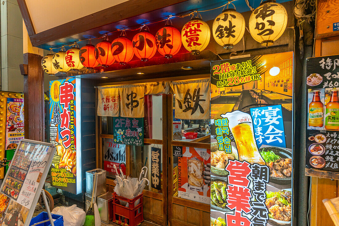 Blick auf bunte Schilder in einer Seitenstraße in Dotonbori, einem pulsierenden Vergnügungsviertel in der Nähe des Flusses, Osaka, Honshu, Japan