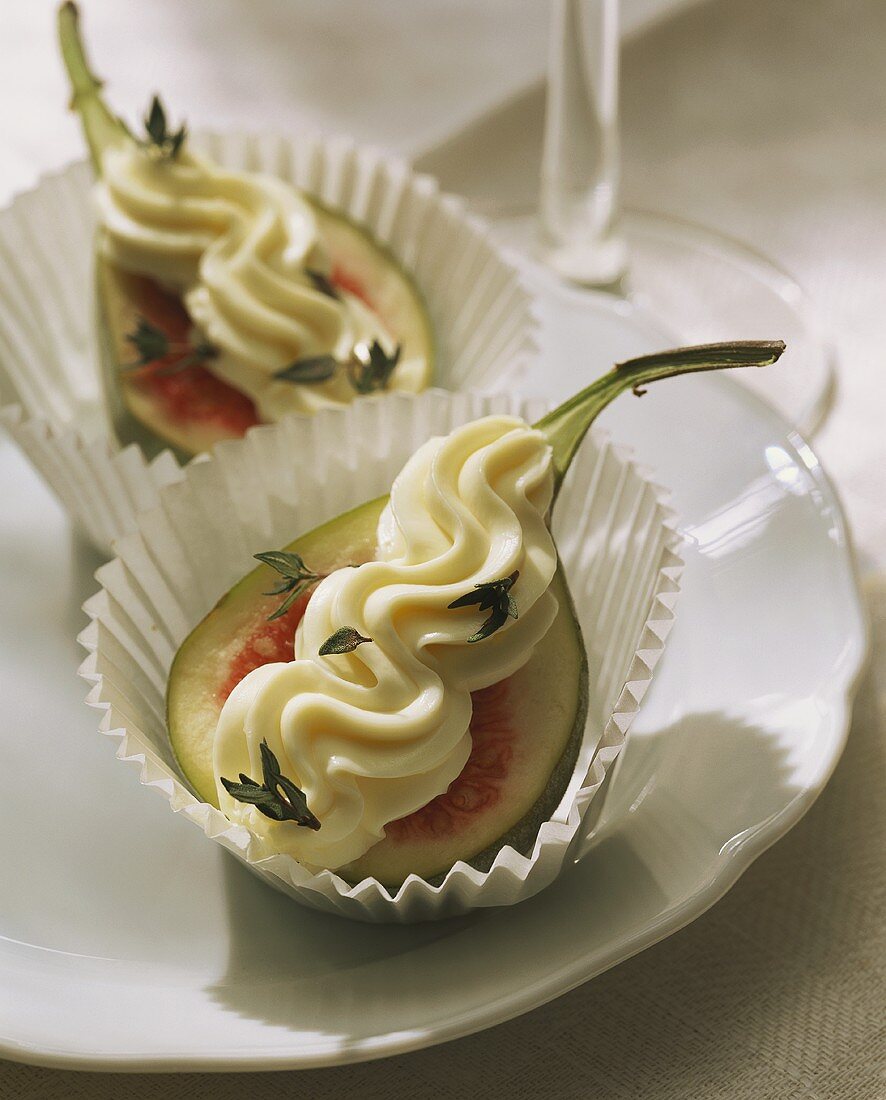 Fig halves with cream cheese topping in paper cases