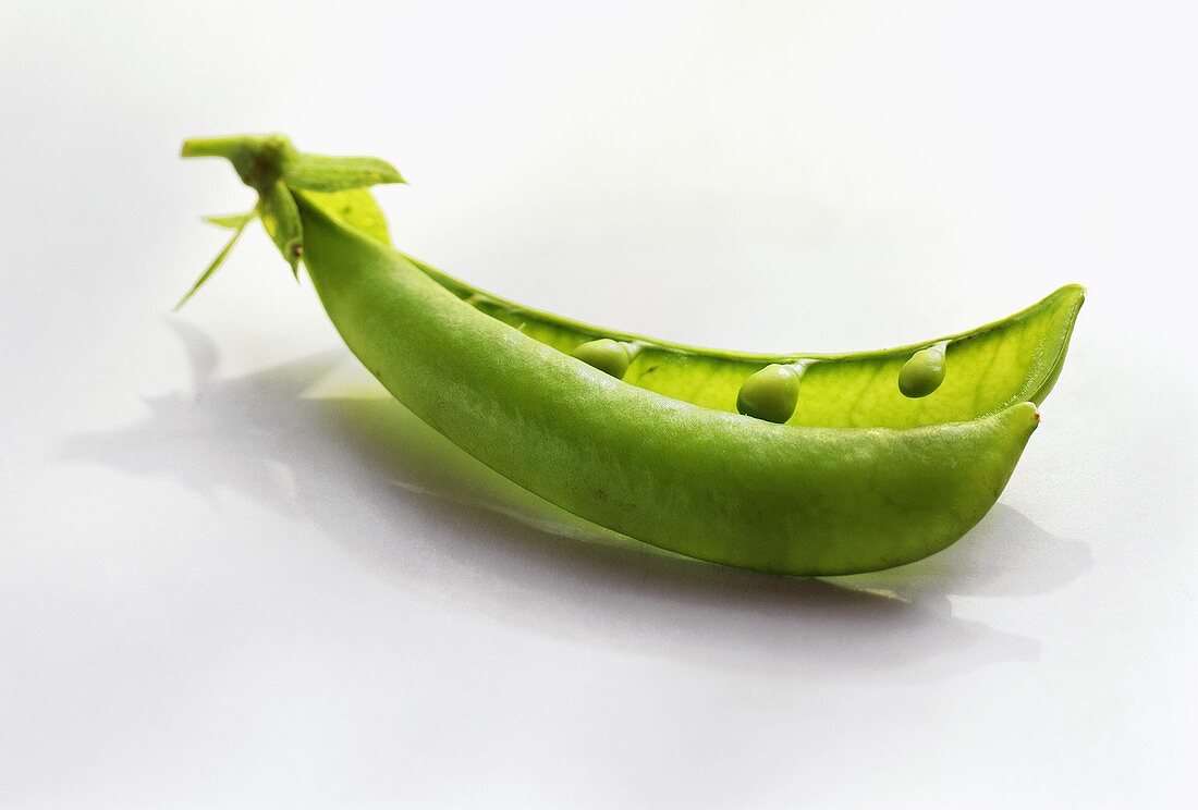Opened pea pod with young peas (sugar peas)