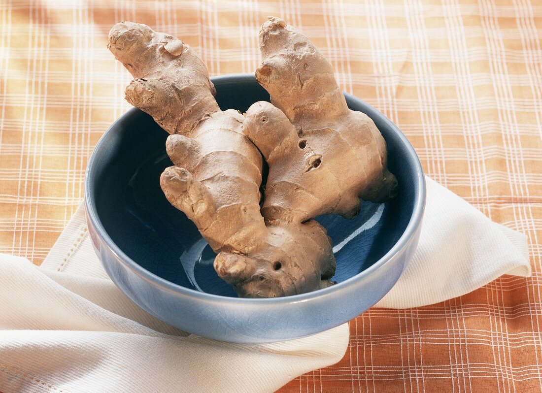 Two ginger roots in a blue bowl