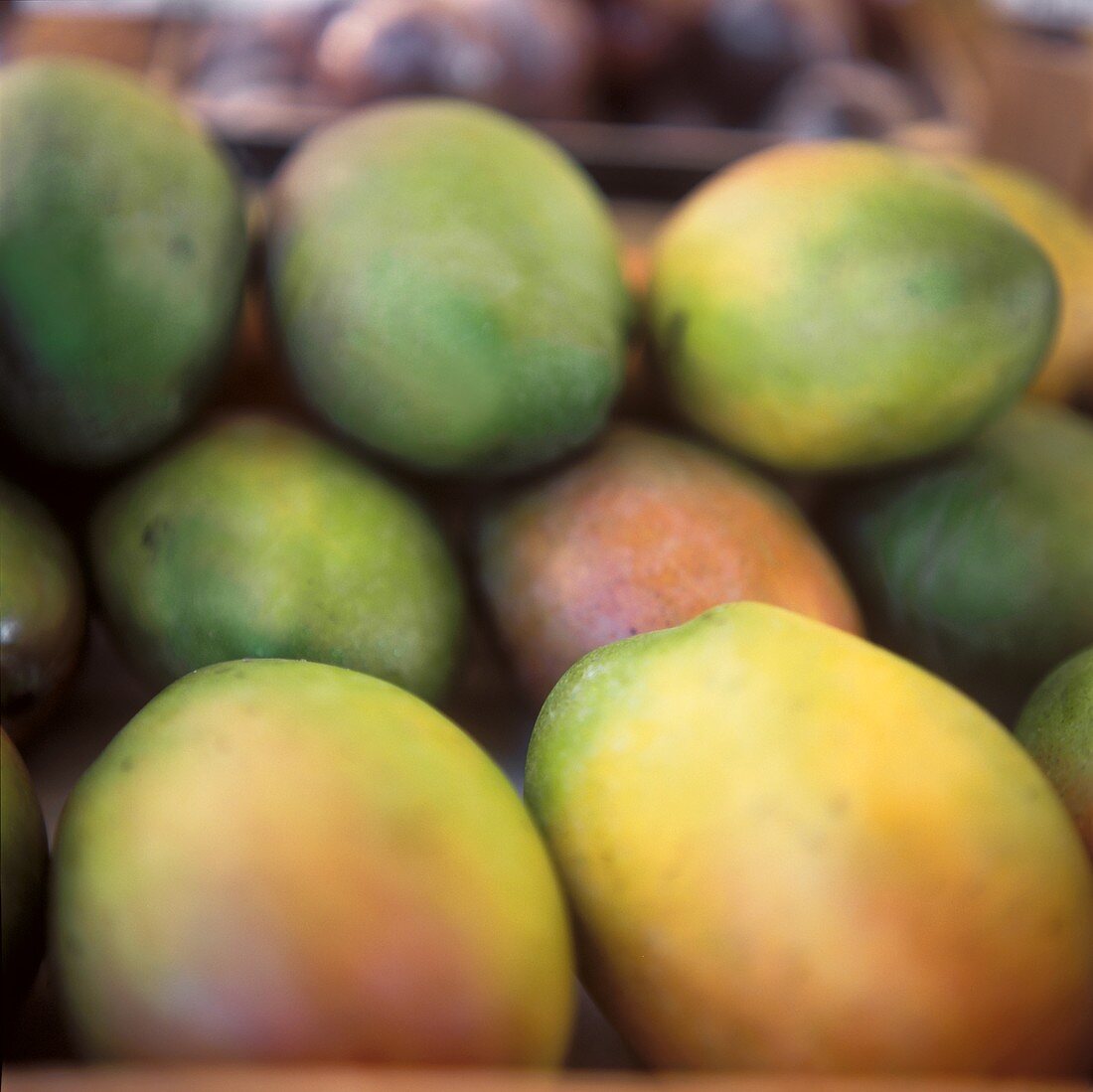 Mehrere Mangos aufeinandergestapelt auf einem Marktstand