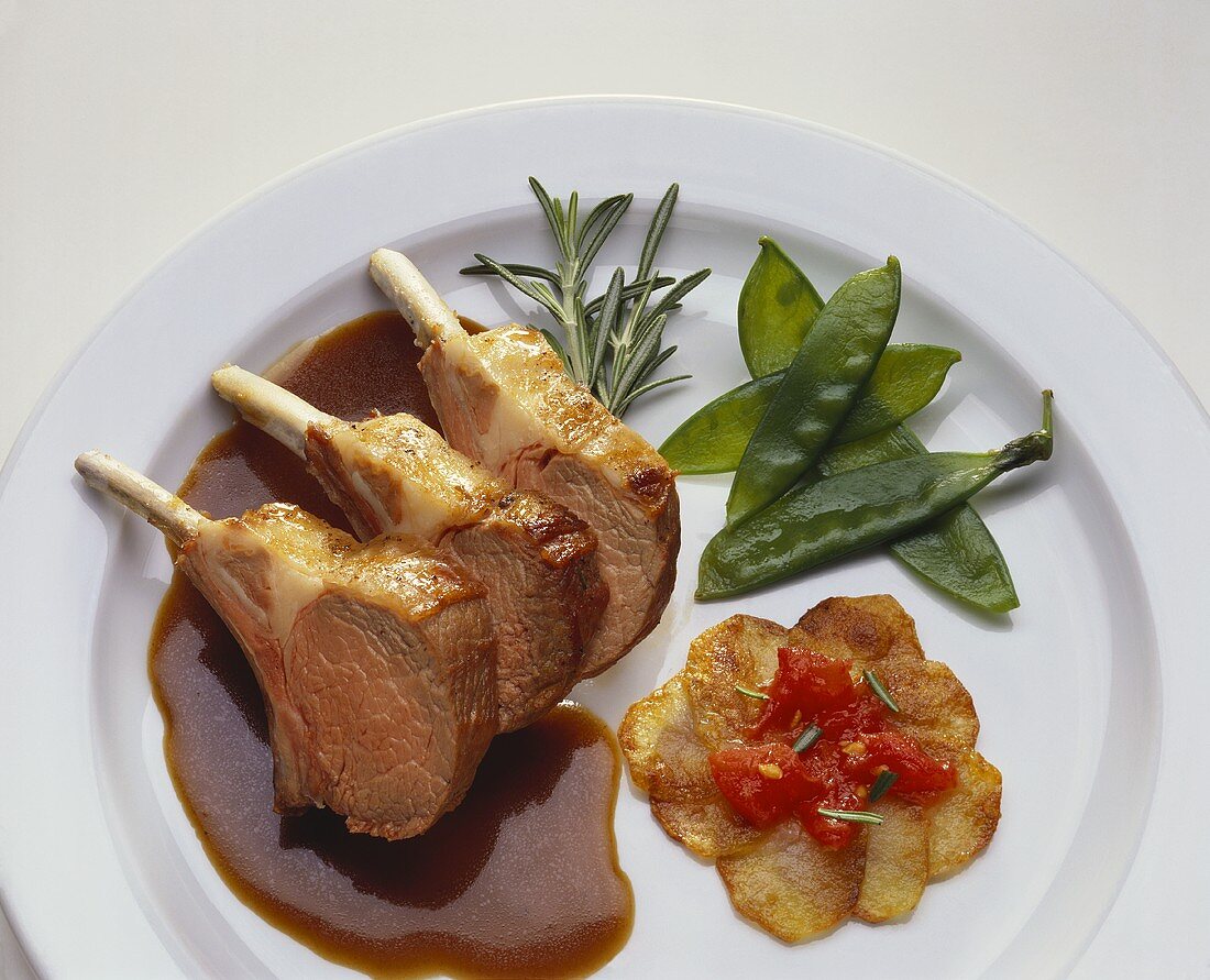 Three lamb chops with gravy and fried potatoes