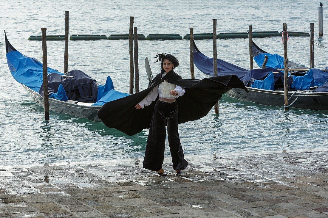 Italien, Venetien, Venedig (UNESCO-Welterbe), Stadtteil San Marco, Markusplatz, Tourist im Karnevalskostüm und Gondeln am Kai der Riva degli Schiavoni