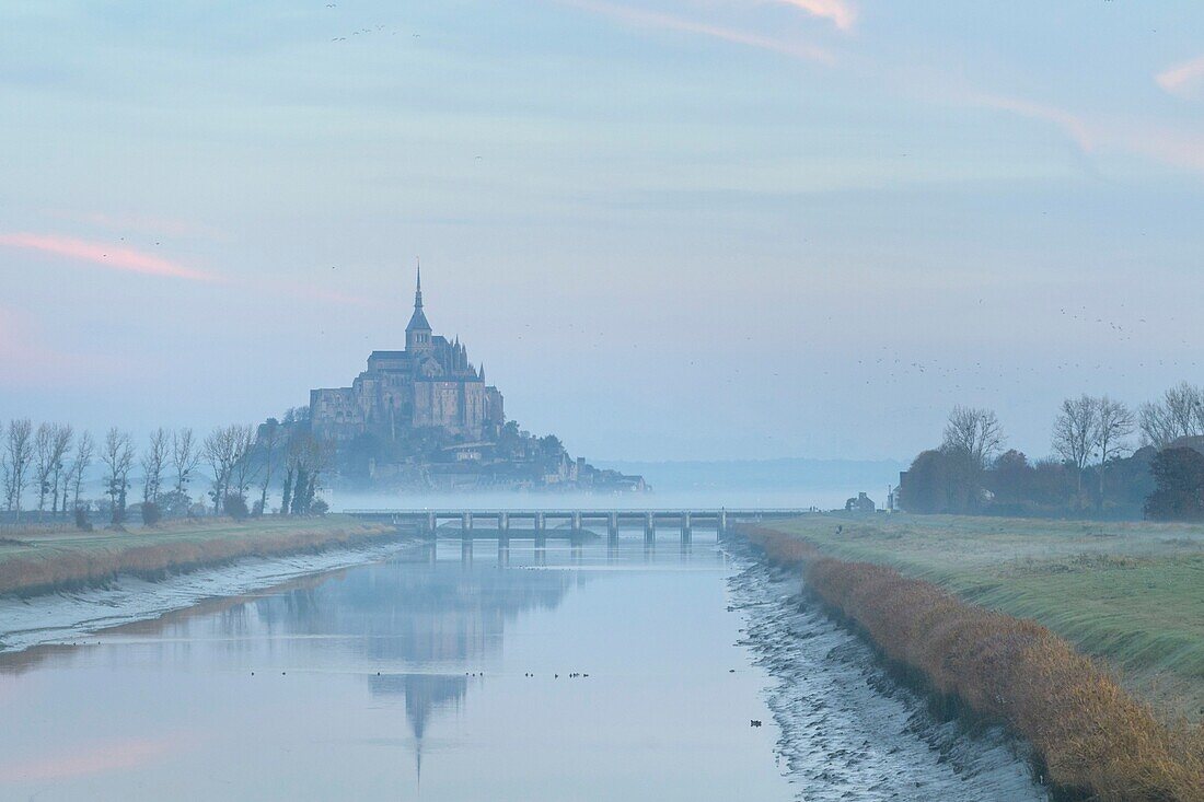 France, Manche, the Mont-Saint-Michel, view of the island and the abbey at sunrise from the mouth of the Couesnon river