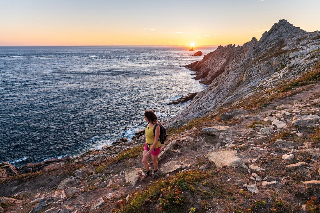 Frankreich, Finistere, Plogoff, Wanderer bei Sonnenuntergang an der Pointe du Raz