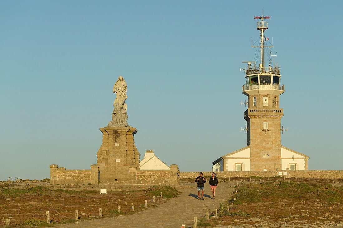 Frankreich, Finistere, Plogoff, Wanderer bei Sonnenuntergang an der Pointe du Raz, vor dem Semaphor