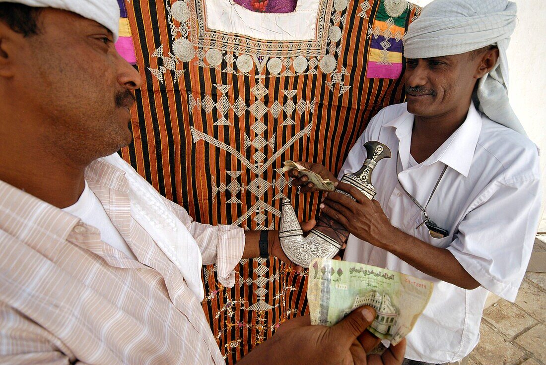 Yemen, Hadhramaut Governorate, Seyoun, small souk, two men haggling the price of a Jambia