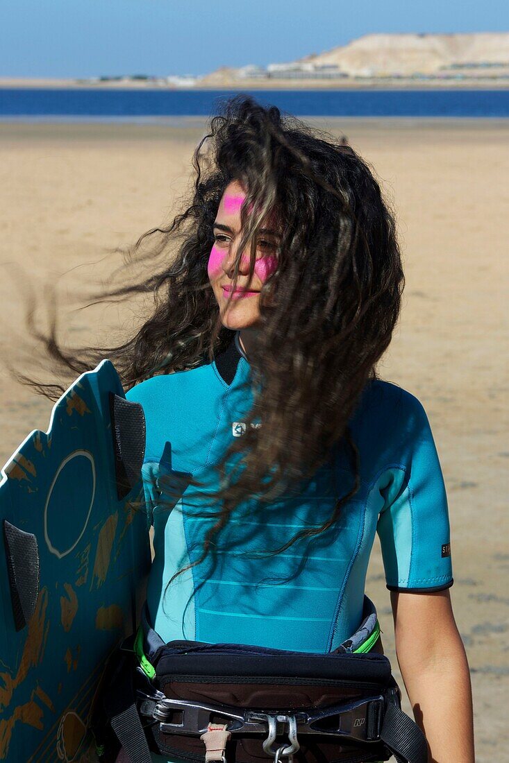 Marokko, Westsahara, Dakhla, junger marokkanischer Kitesurfer mit Haaren am Strand im Kitecamp Dakhla Attitude