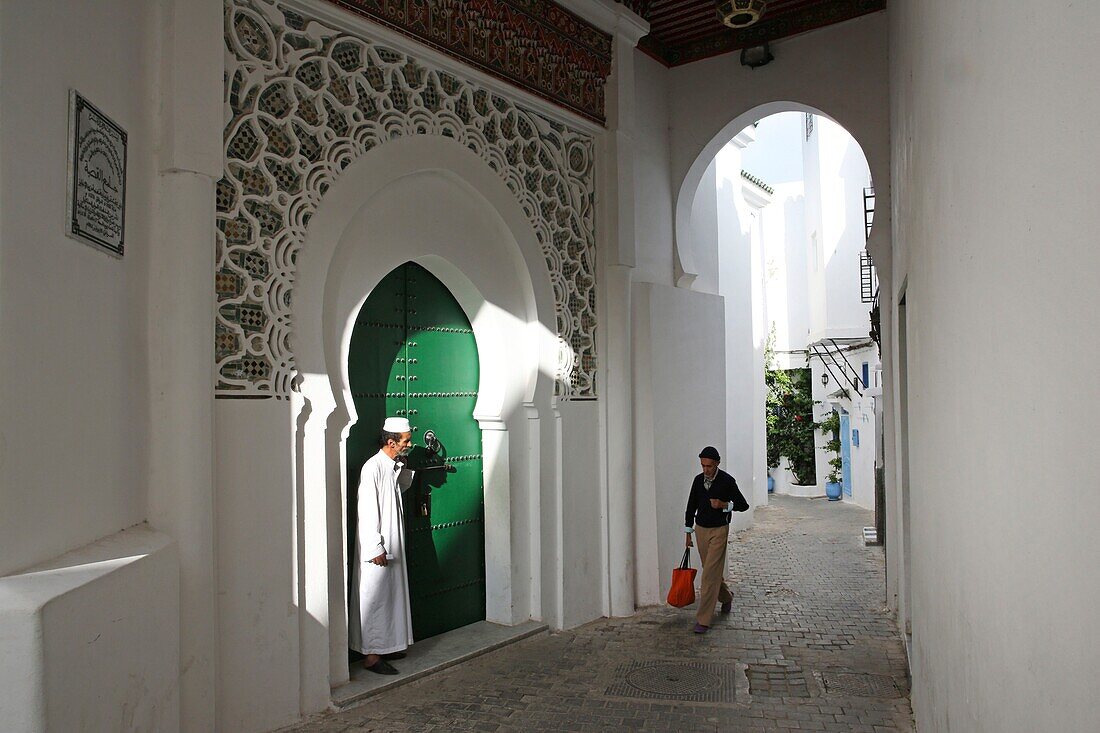 Marokko, Tanger Region Tetouan, Tanger, alte Tangerois in einem gewölbten Gang vor der Tür einer Moschee