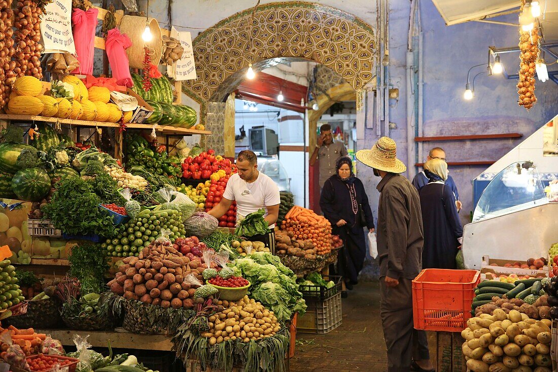 Marokko, Tanger Region Tetouan, Tanger, Marokkaner beim Einkaufen vor einem Obst- und Gemüsestand auf dem Souk