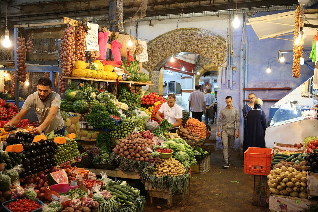 Marokko, Tanger Region Tetouan, Tanger, Marokkaner beim Einkaufen vor einem Obst- und Gemüsestand auf dem Souk