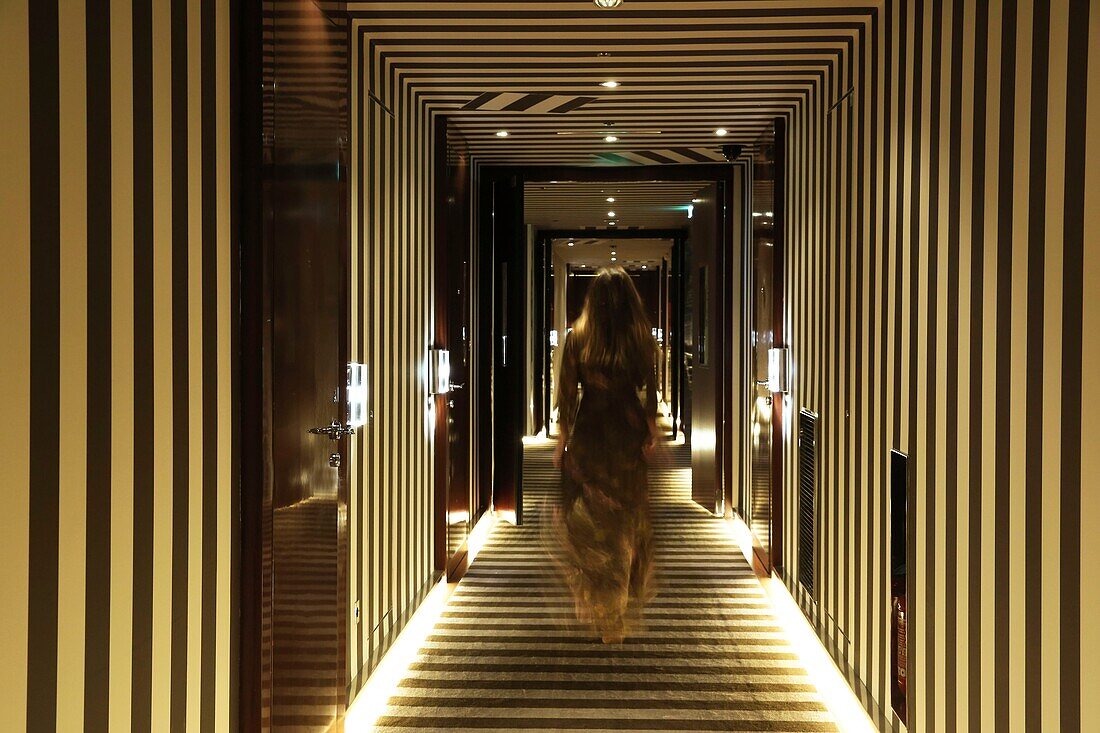 Frankreich, Paris, Royal Monceau Hotel, Frau im Abendkleid in einem Korridor mit grafischen Motiven des Royal Monceau