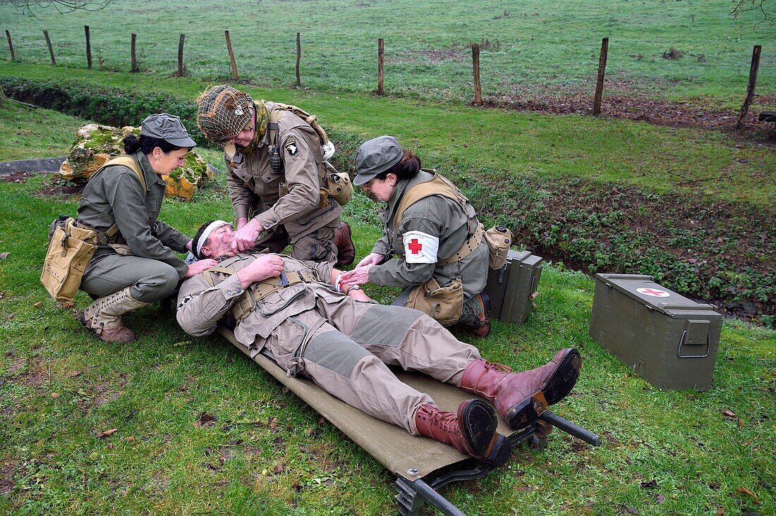 Frankreich, Eure, Sainte Colombe prés Vernon, Allied Reconstitution Group (US World War 2 and french Maquis historical reconstruction Association), Reenactors in Uniform der 101st US Airborne Division und Krankenschwestern, die sich um einen verwundeten Soldaten kümmern