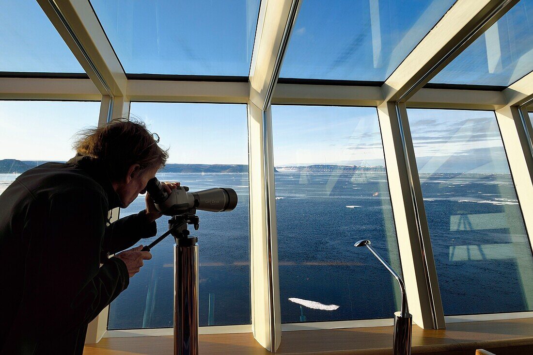 Grönland, Nordwestküste, Smith-Sund nördlich der Baffin Bay, Hurtigruten-Kreuzfahrtschiff MS Fram, Passagier beobachtet das arktische Meereis aus dem Panoramaraum