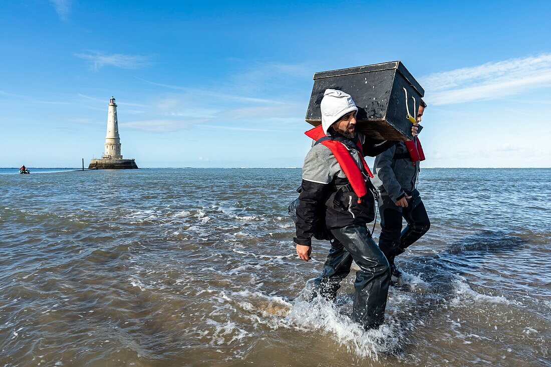 Frankreich, Gironde, Verdon sur Mer, Felsplateau von Cordouan, Leuchtturm von Cordouan, von der UNESCO in die Liste des Weltkulturerbes aufgenommen, Porträt der Leuchtturmwärter vor dem Linsenrastersystem des Leuchtturms