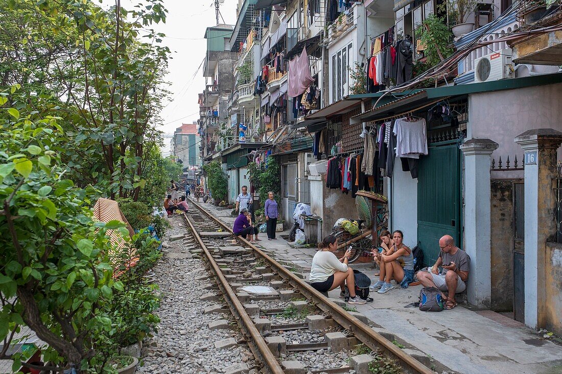 Vietnam, Hanoi, Eisenbahn, die im Herzen der Altstadt vorbeifährt, Touristen warten auf die Durchfahrt eines Zuges