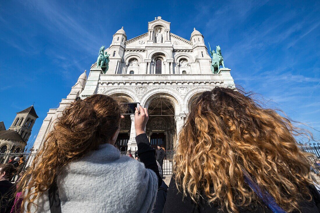 France, Paris, Montmartre, a young tourist photograph the Basilica of the Sacre Coeur