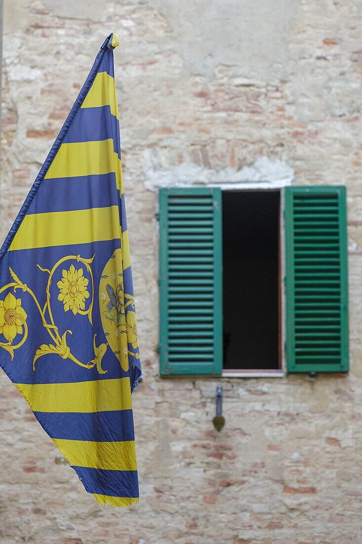 Italy, Tuscany, Siena, historical center listed as World Heritage by UNESCO, banner of the Tortuca (Turtoise) condrade hanged on a facade in the historical center