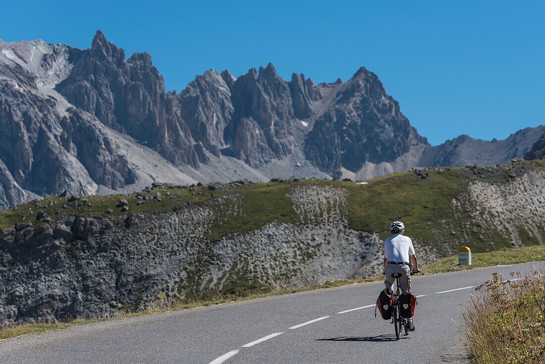 France, Savoie, Massif des Cerces, Valloire, cycling ascension of the Col du Galibier, one of the routes of the largest cycling area in the world, an itinerant cyclist apprecie the grandiose landscape of the steep reliefs of the massif des Cerces