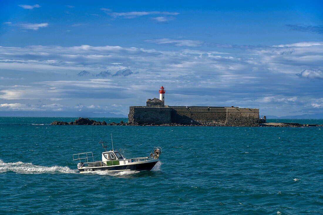 France, Herault, Agde, Cape of Agde, Fort of Brescou with a fishing boat in the foreground