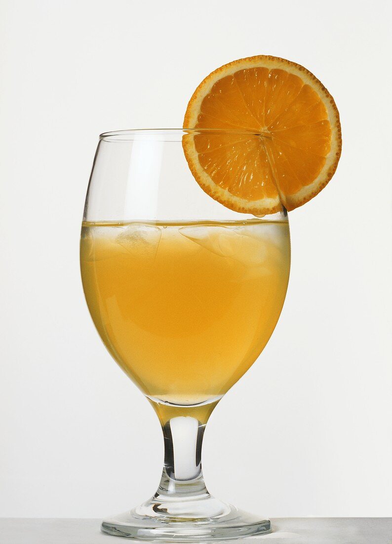A glass of orange juice, garnished with orange slice