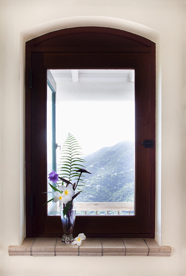 Tropische Blumen in Vase am Fenster