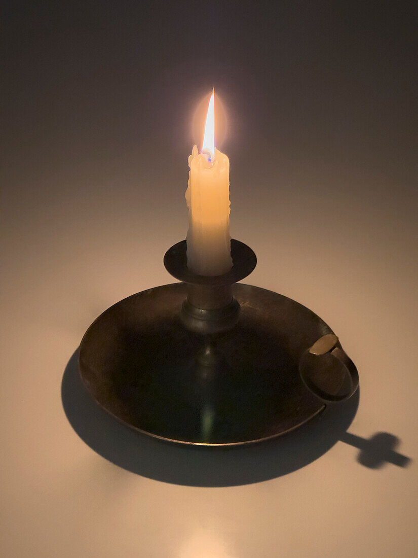 Studio shot of candle in candlestick holder