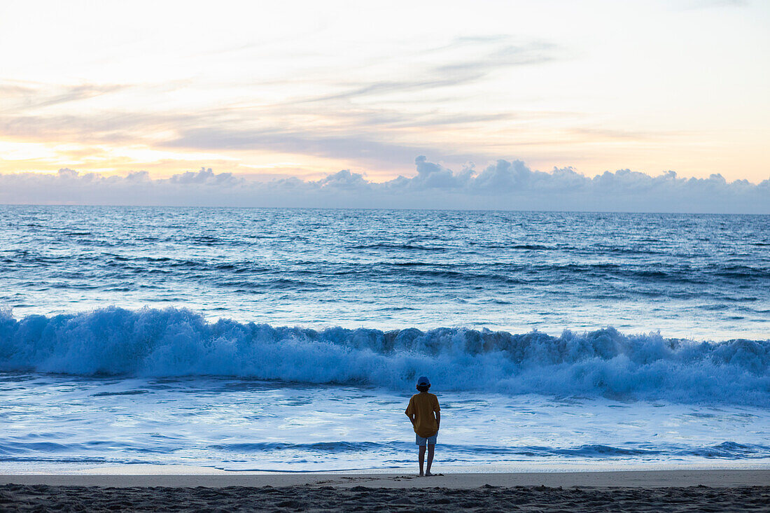 Mexiko, Baja, Pescadero, Silhouette eines Jungen am Strand in der Abenddämmerung