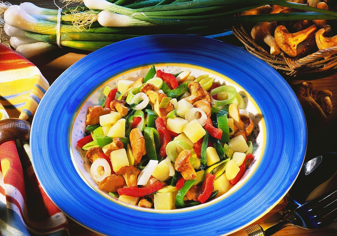 Frühlingszwiebel-Gemüse-Salat mit Pfifferlingen auf Teller