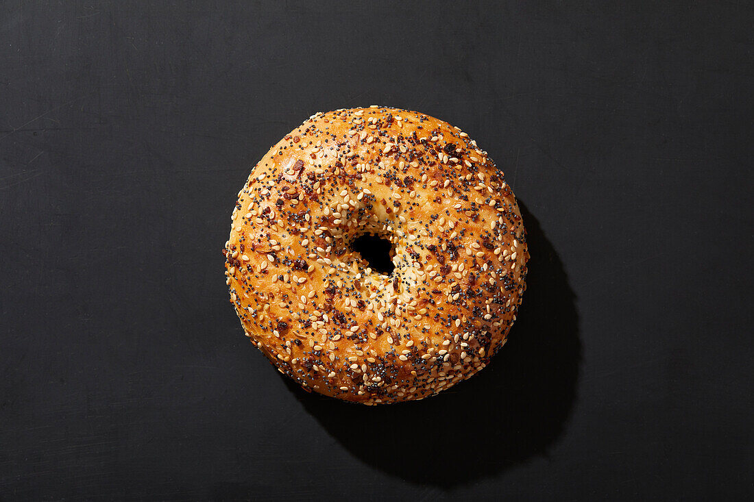 Draufsicht auf Bagel mit Kernen auf schwarzem Hintergrund