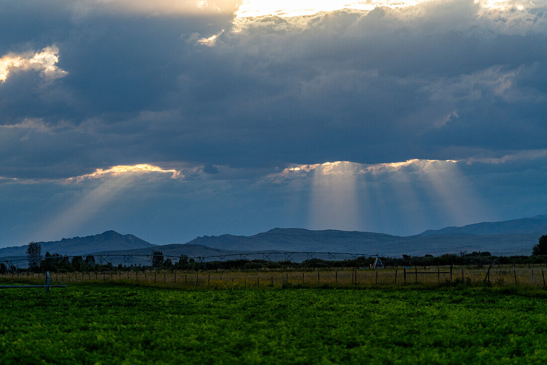 Sonnenlicht, das bei Sonnenuntergang durch dunkle Wolken scheint