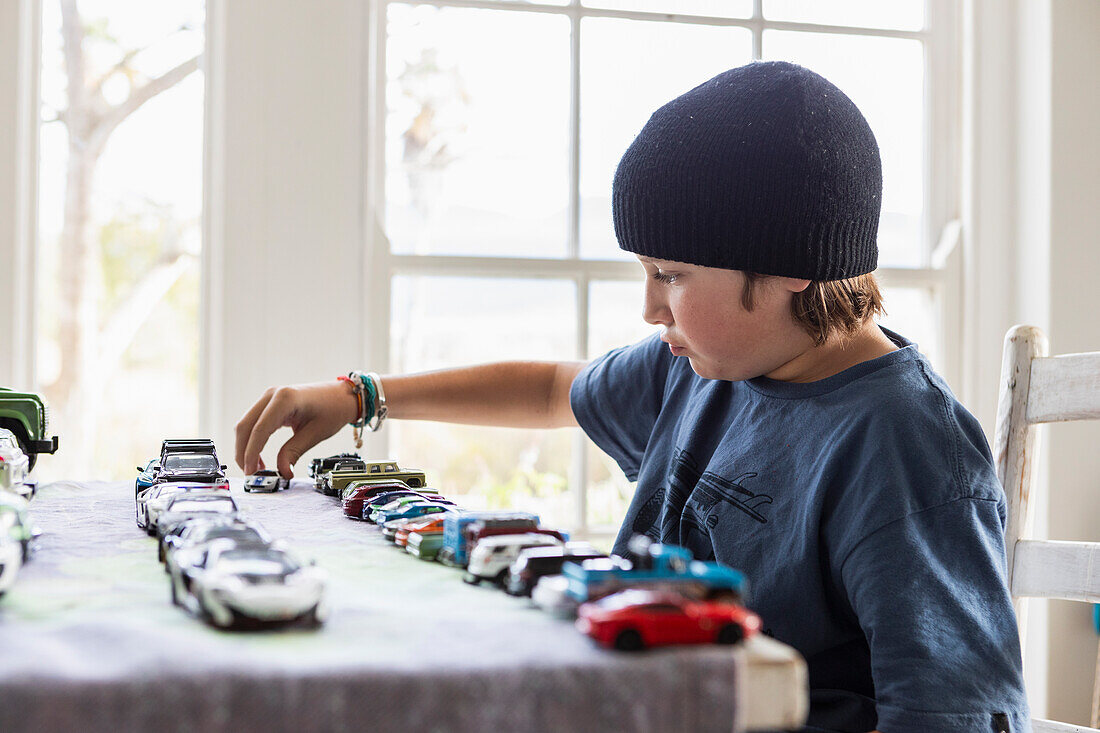 Boy (10-11) playing with toy cars at home