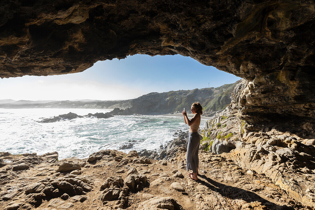 South Africa, Hermanus, Teenage girl (16-17) exploring Klipgat Caves in Walker Bay Nature Reserve