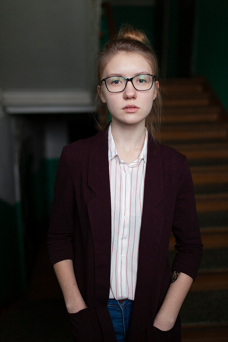 Portrait of serious woman standing with hands in pockets at home