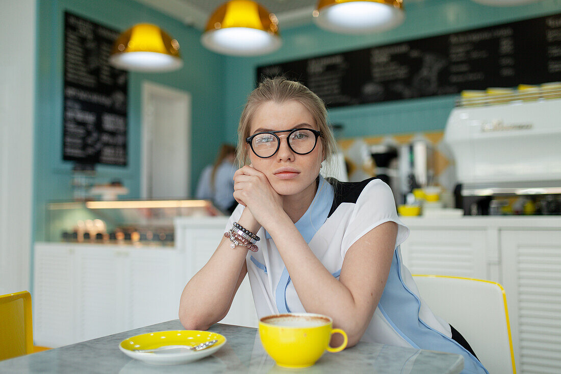 Porträt einer ernsten Frau, die in einem Café sitzt