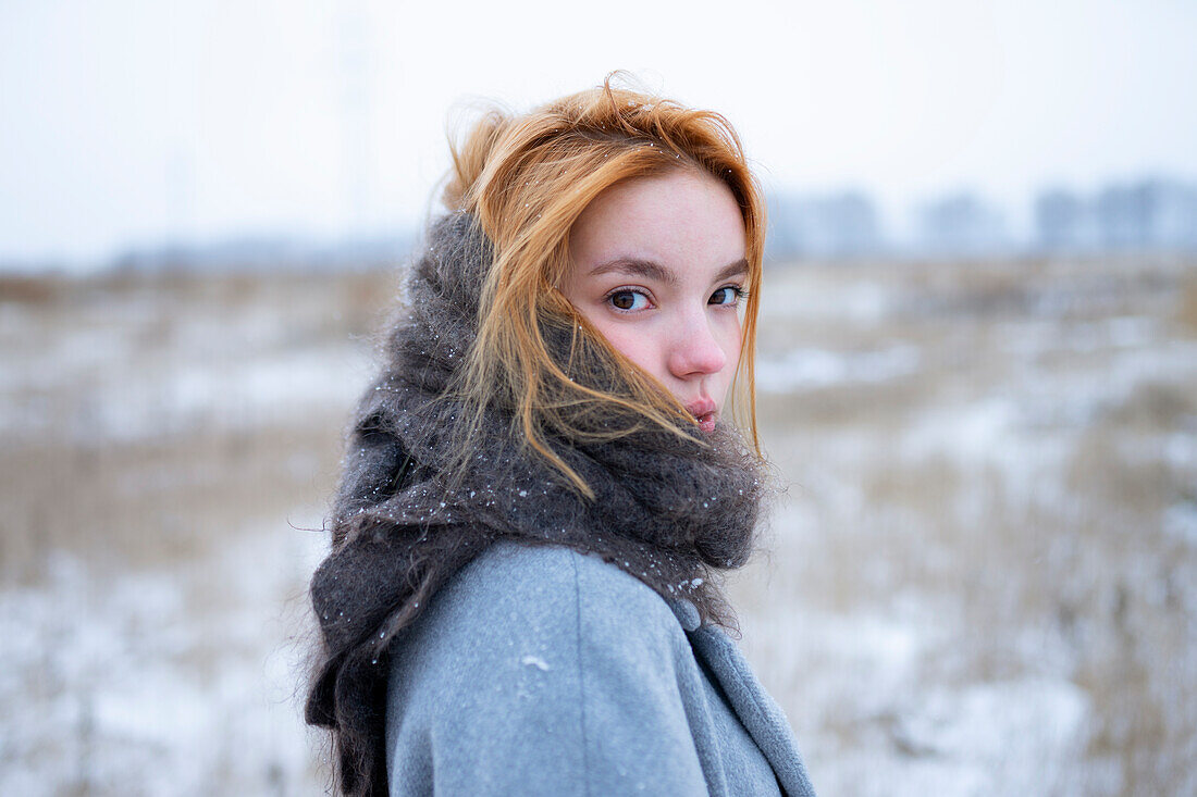 Portrait of young woman standing in snowy landscape