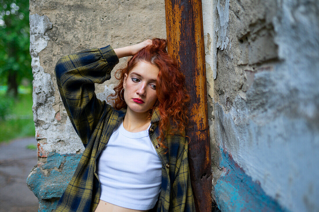 Portrait of thoughtful woman leaning on building wall