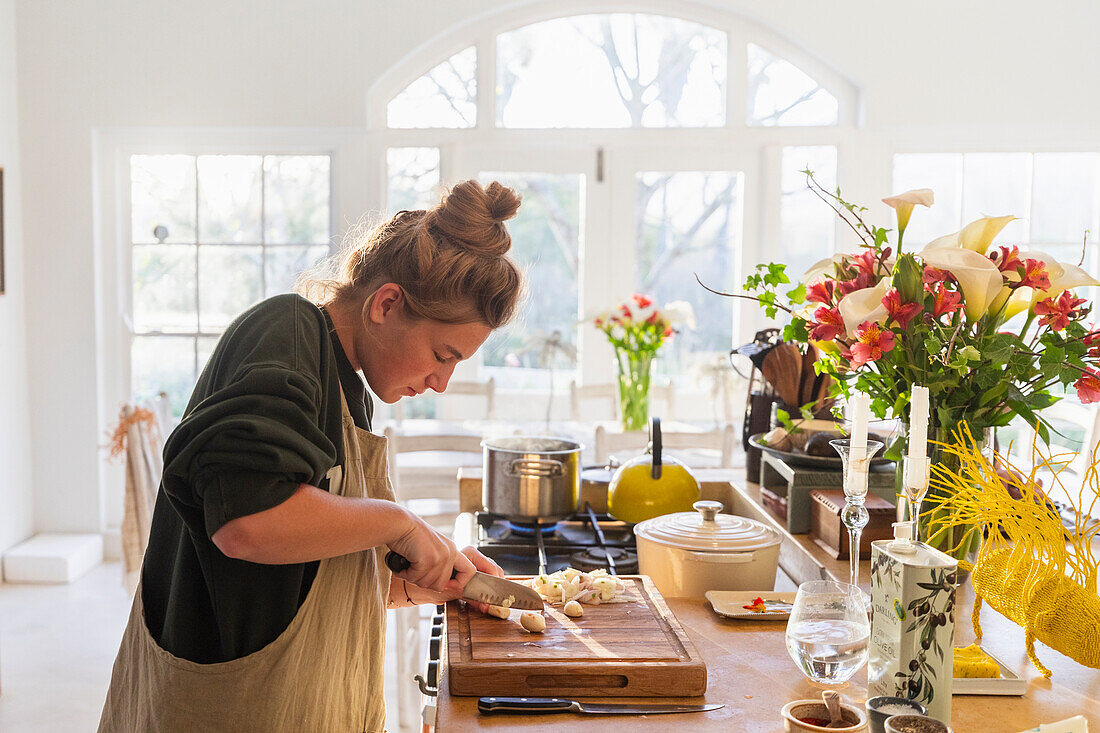 Teenage girl (16-17) preparing meal in kitchen